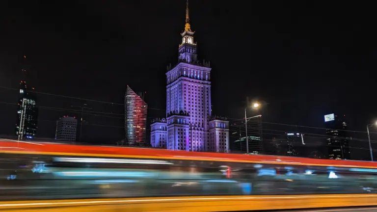 Warszawa wieczorem, Pałac Kultury i Nauki oraz rozmyty tramwaj w ruchu miejskim.