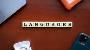 Klocki z literami układające się w słowo języki na drewnianym stole