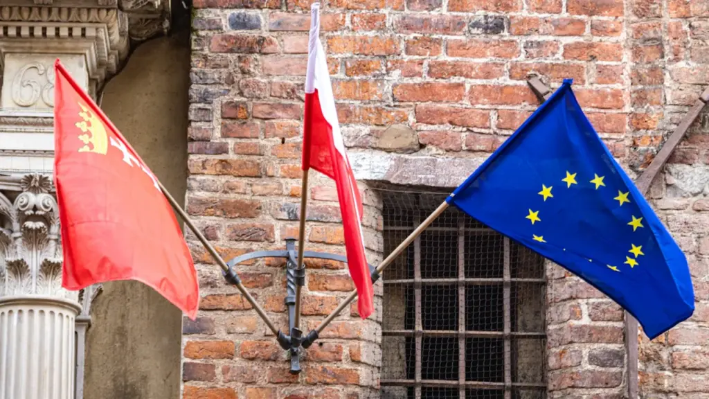 Flagi Gdańska, Polski oraz Unii Europejskiej na zabytkowej ścianie budynku ratusza w Gdańsku.