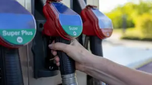 Dłoń trzymająca pistolet dystrybutora paliwa na stacji benzynowej, przygotowanie do tankowania samochodu.