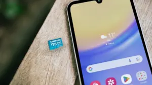 Smartfon z kartą pamięci na drewnianym blacie, symbolizujący zwiększanie przestrzeni na pliki.
